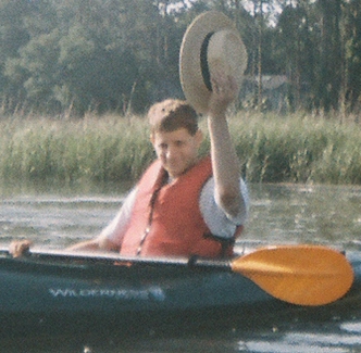 Art waving while sitting in a kayak.