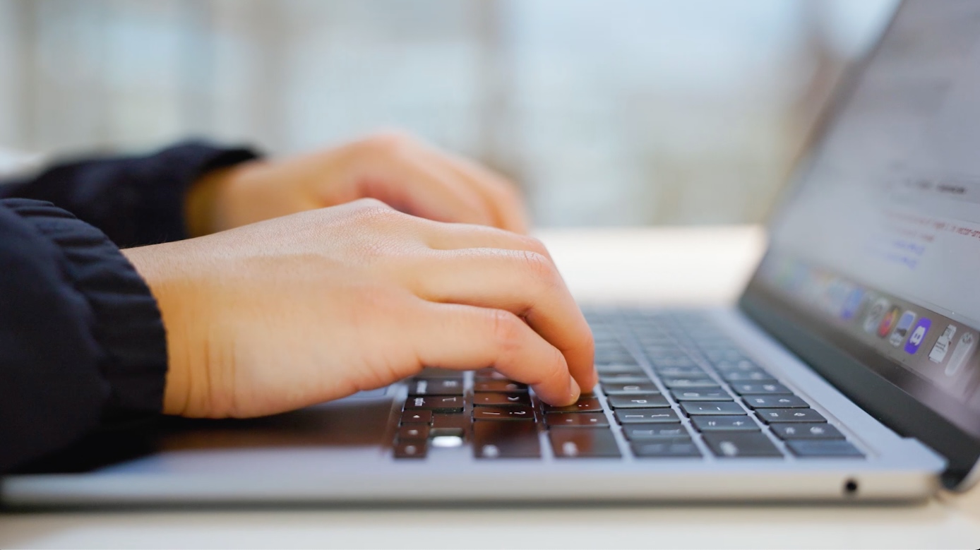 hands typing on a laptop