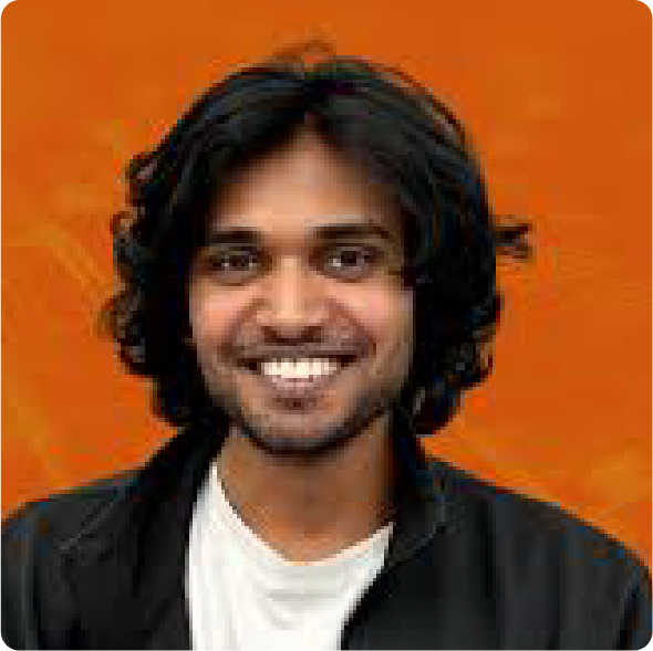 A color photo of a man smiling for a photo with an orange background.