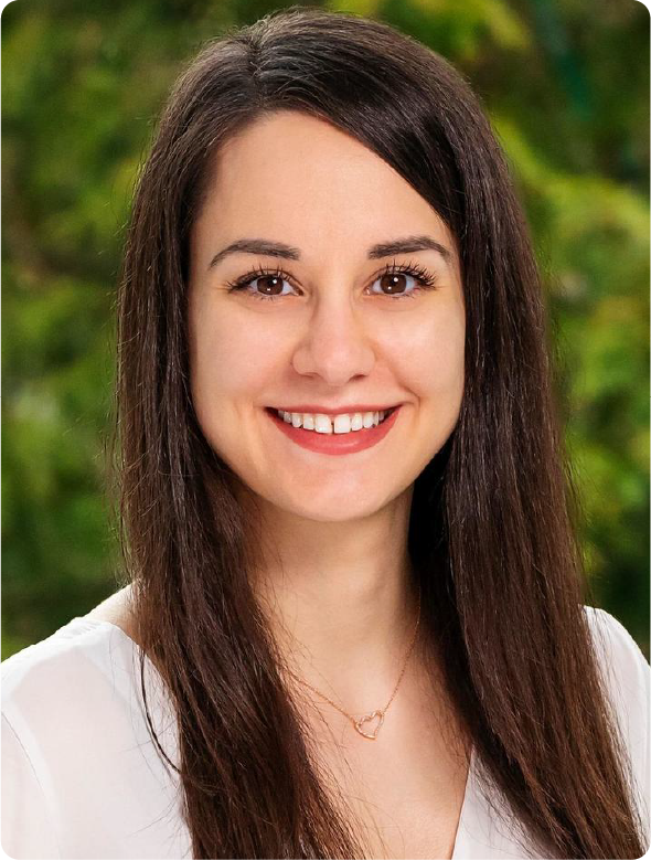A color photo of a woman smiling for a photo.