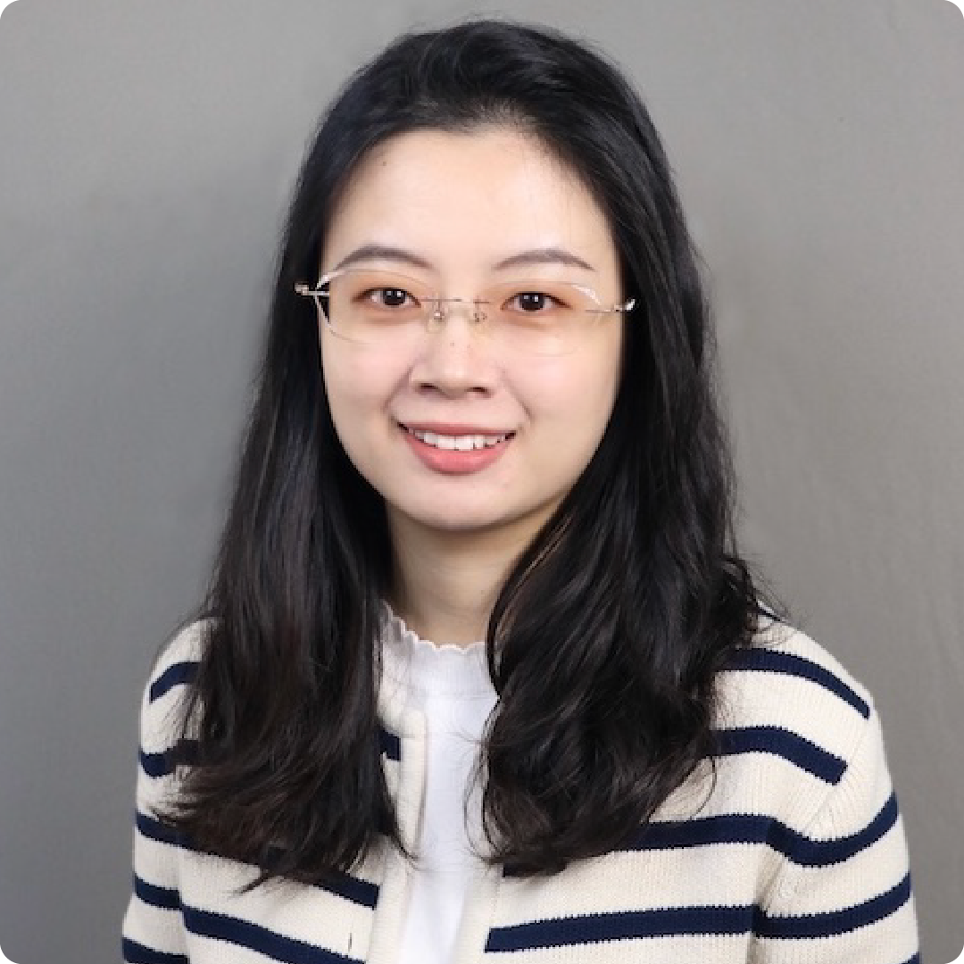 A color photo of a woman with glasses, smiling for a portrait.