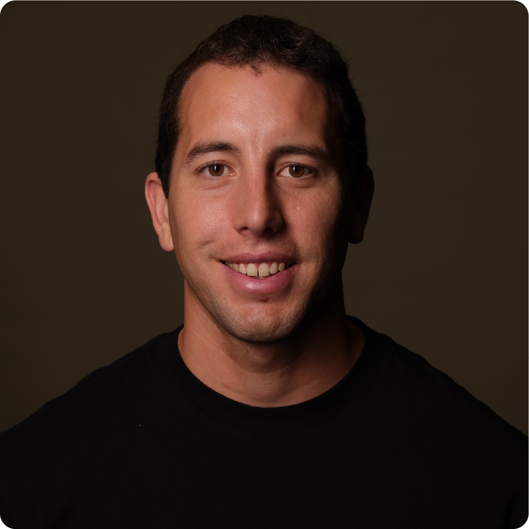 A color photo of a man smiling for a protrait.