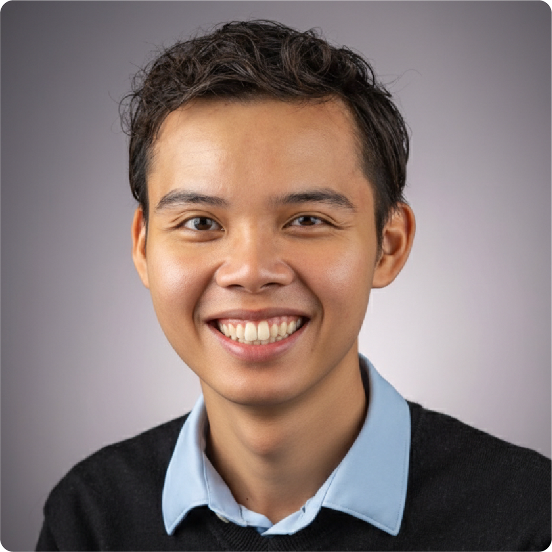 A color photo of a man smiling for a portrait.