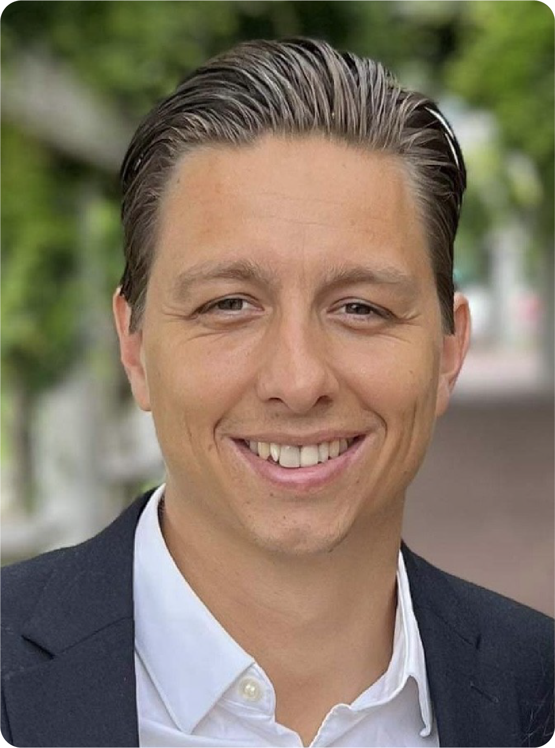 A color photo of a man smiling for a photo.