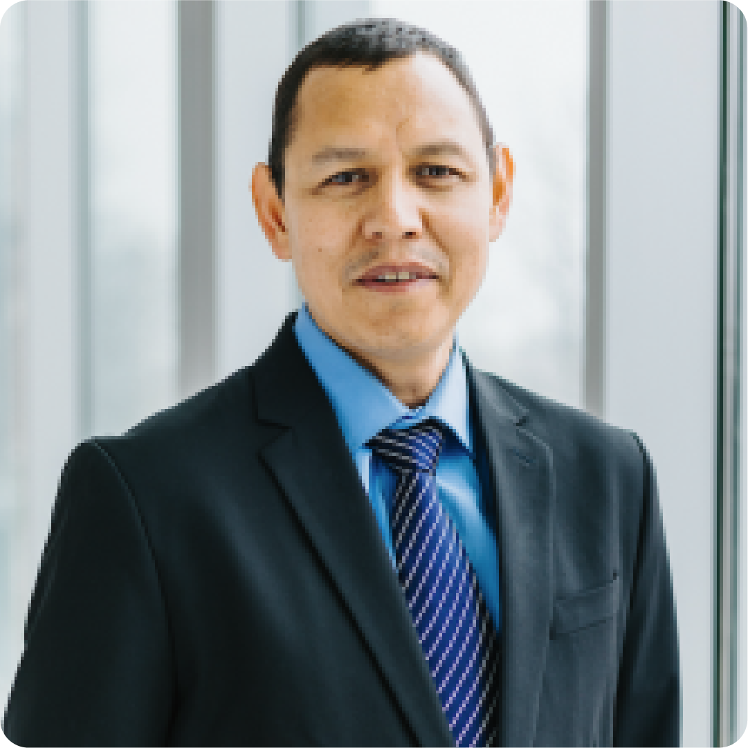 A color photo of a man wearing a suit and tie.