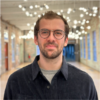 A color photo of a man with glasses.