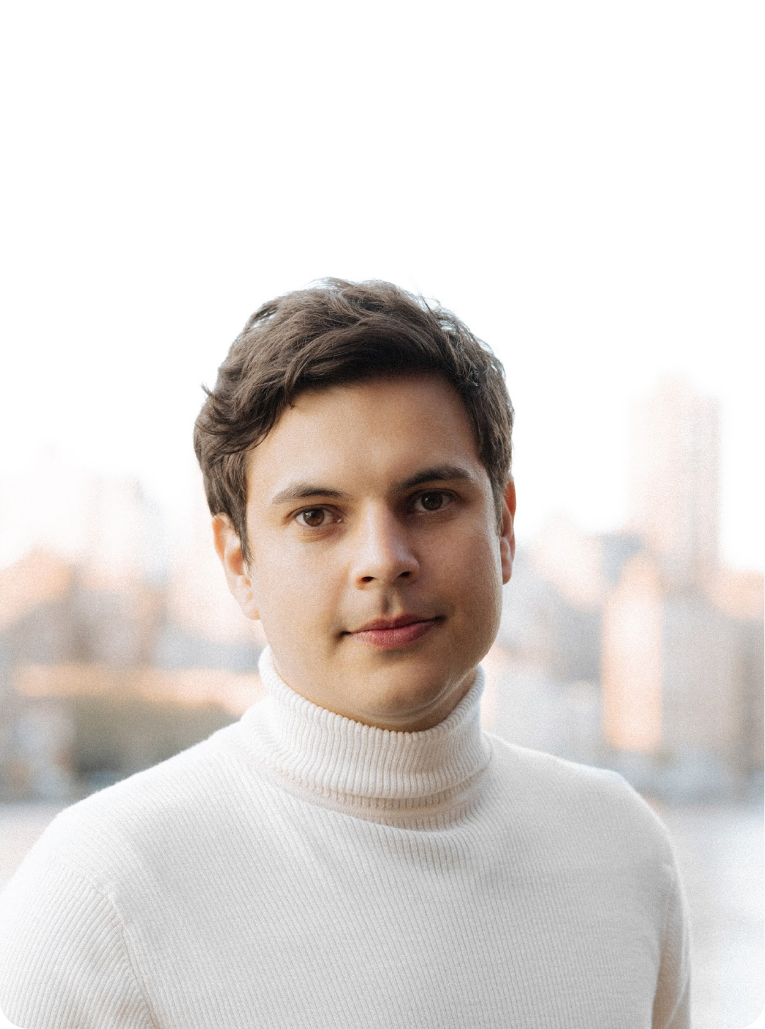 A color photo of a person in a white turtleneck sweater.