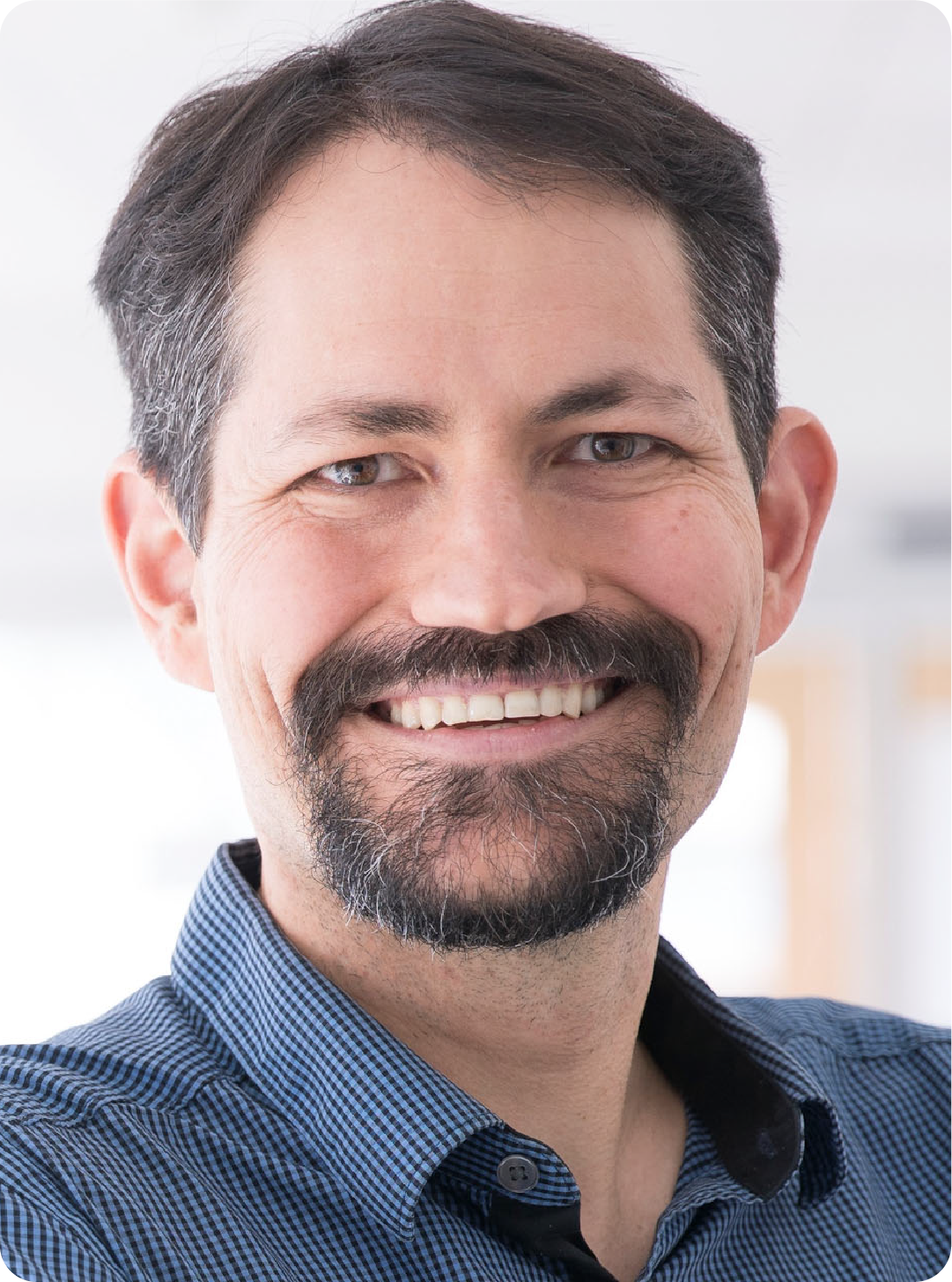 A color photo of a man smiling or a photo.