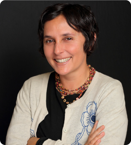A color photo of a woman smiling for a photo.