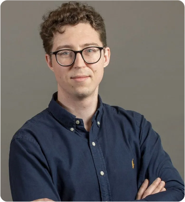 A color photo of a man with glasses.