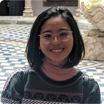 A color photo of a woman smiling for a photo.