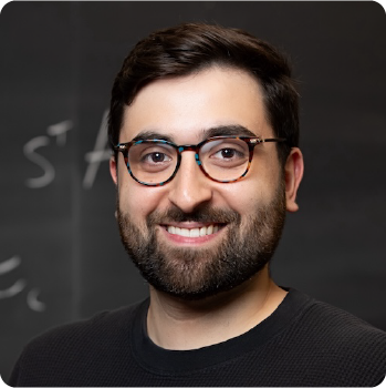 A color photo of a man with glasses and a beard.