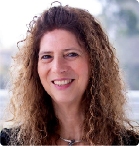 A color photo of a woman smiling for a photo.