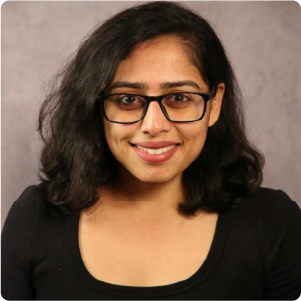 A color photo of a woman smiling for a photo.