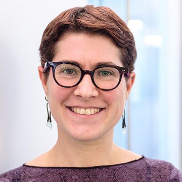 A color photo of a woman with glasses.