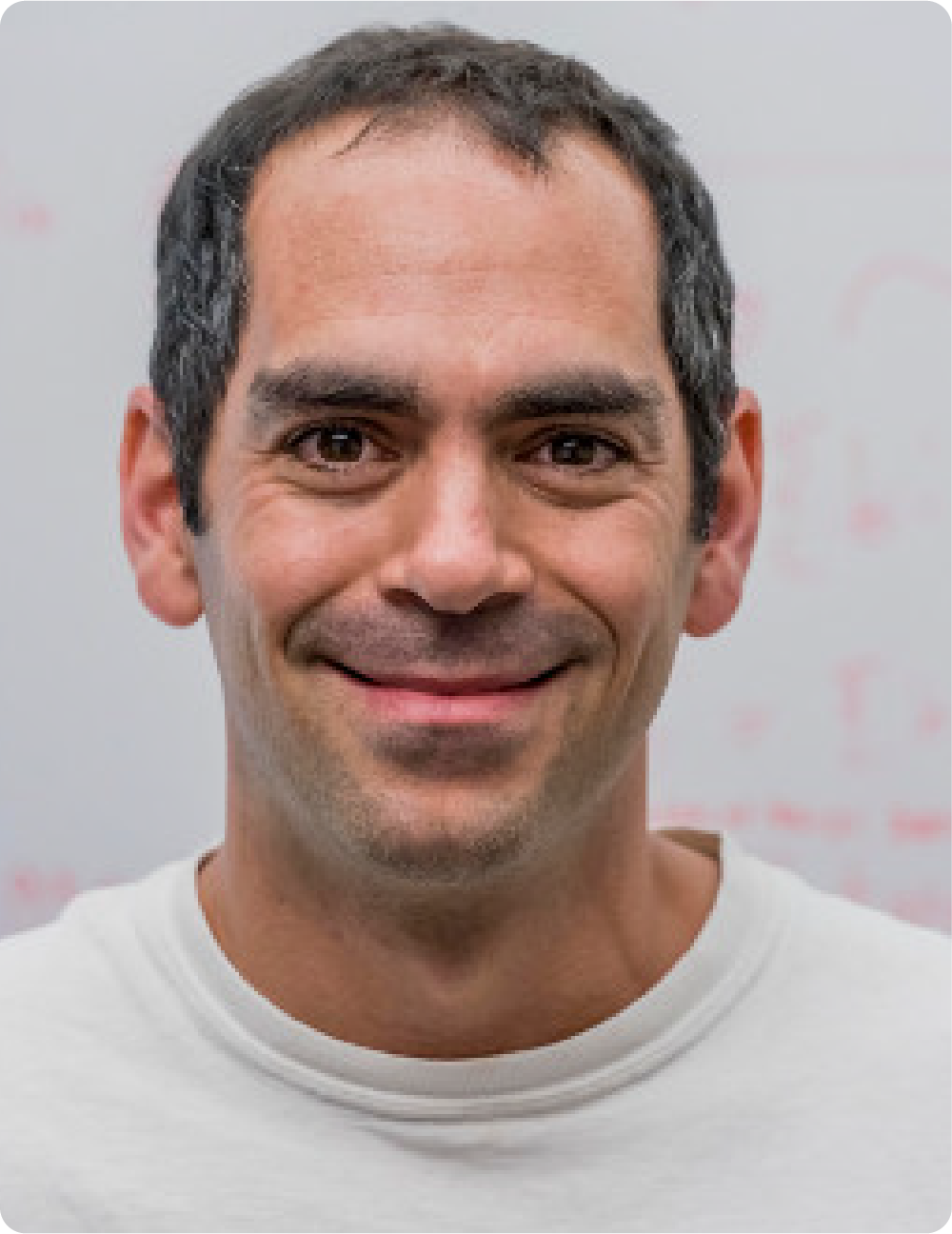 A color photo of a man smiling for a photo.