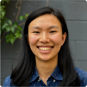 A color photo of a woman smiling for a photo.
