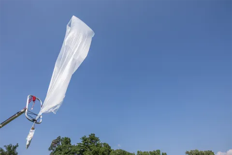 A color photo showing a weather balloon about to take flight.