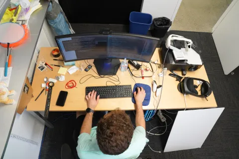 birds eye view of a male student working on a computer at a desk
