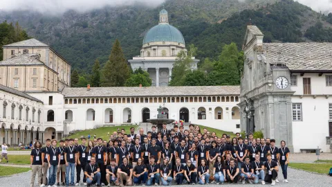 A color photo showing a large group of students in front of an Italian cathederal.