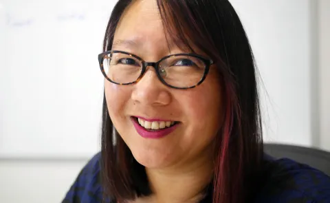 Woman in glasses smiling at camera, 