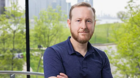 A color photo of a man smiling for a portrait.