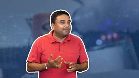 A color photo showing a man wearing a red shirt.