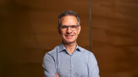 A photo of Stephen Marschner, a smiling man in front of a brown background