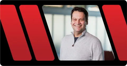 A color photo of a man smiling for a photo.