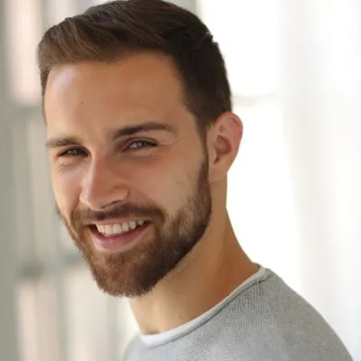 Yann Hicke wears a gray sweater and stares at the camera