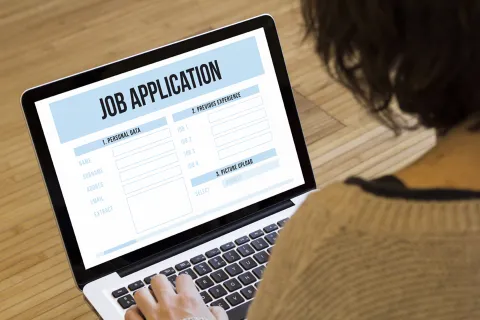 Person views a laptop screen that displays "Job Application"