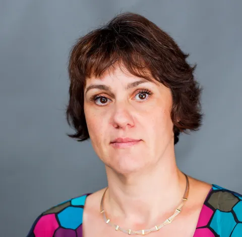 Color photo of woman with chin length brown hair