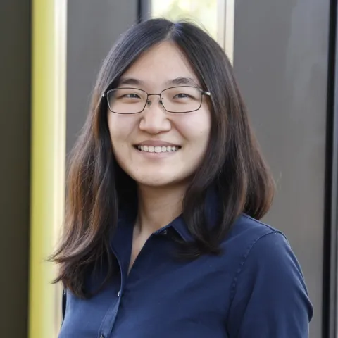 A photo of Jennifer J. Sun, a woman with long dark hair, glasses and a blue shirt