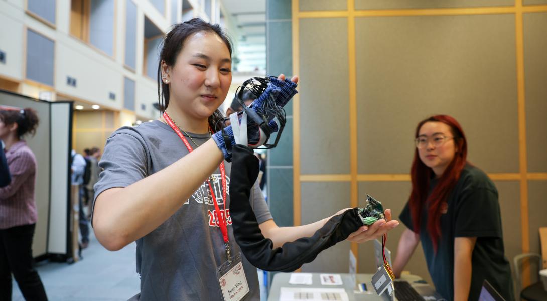 A color photo of a woman wearing a hand tracking glove.