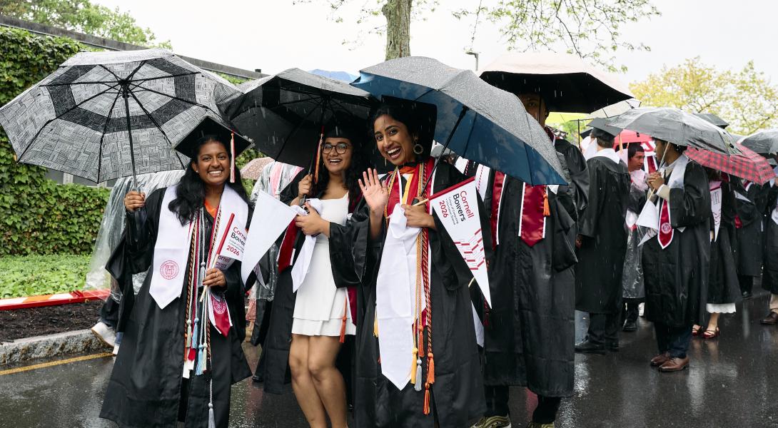 a group of female graduates pose under their umbrellas