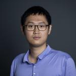 A color photo of a man with glasses.