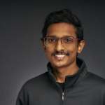 A color photo of a man with glasses.