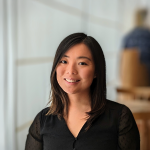A color photo of a woman smiling for a photo.