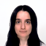 A color photo of a woman smiling for a photo.