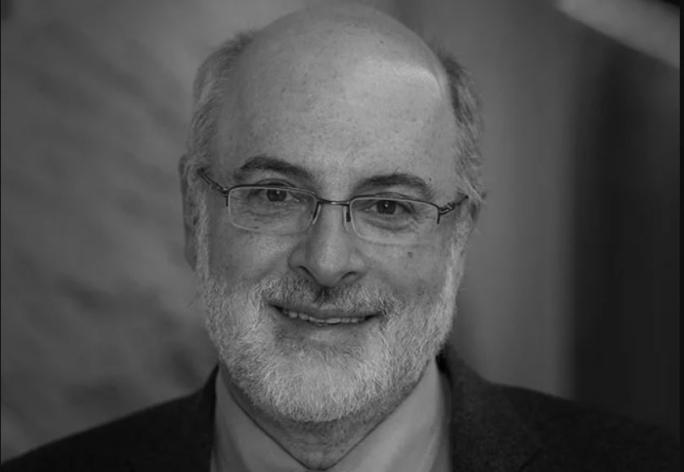 A black and white photo of Kenneth Birman, a man with glasses wearing a suit and tie.