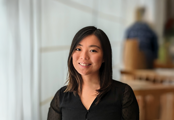 A color photo of a woman smiling for a photo.