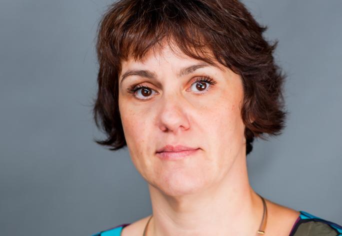 Color photo of woman with chin length brown hair