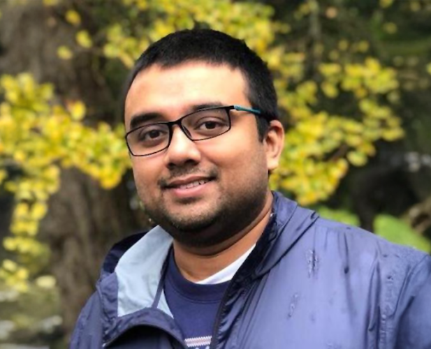 A color photo of Tapomayukh Bhattacharjee, a man with glasses, short dark hair and gray jacket