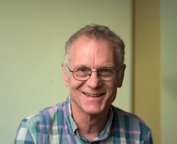 A photo of Dexter Kozen, a smiling man with short gray hair, glasses and a plaid shirt