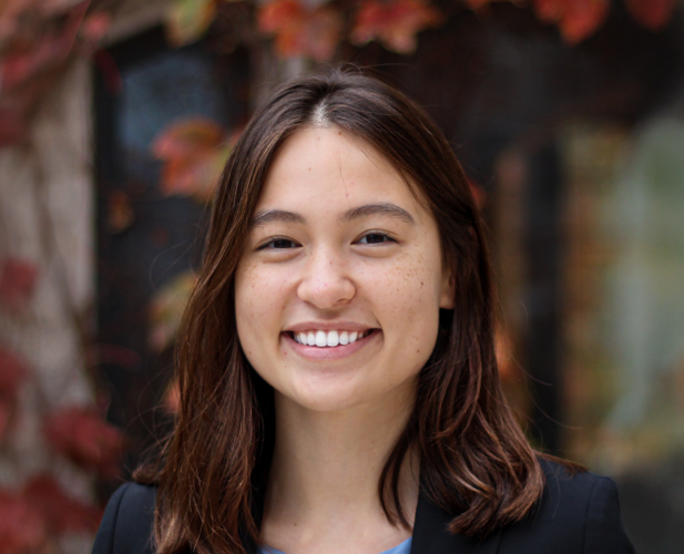 A color photo of a woman smiling for a photo.