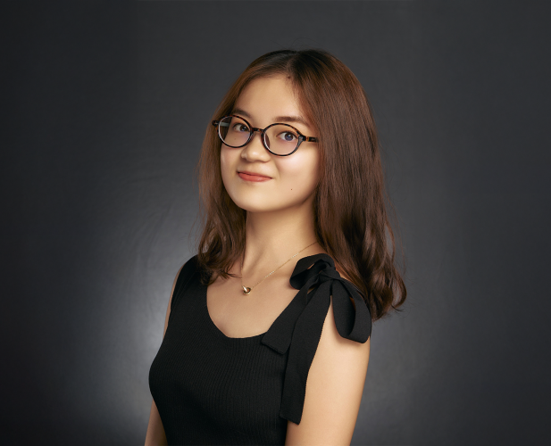 A color photo of a woman smiling for a photo.