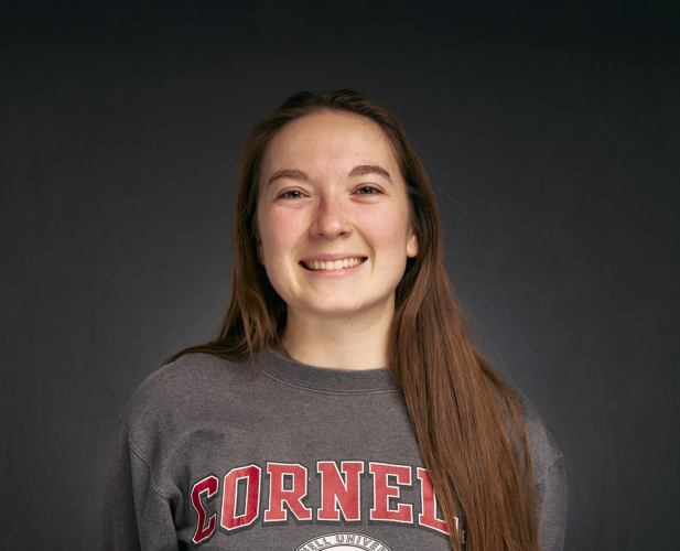A color photo of a woman smiling for a photo.