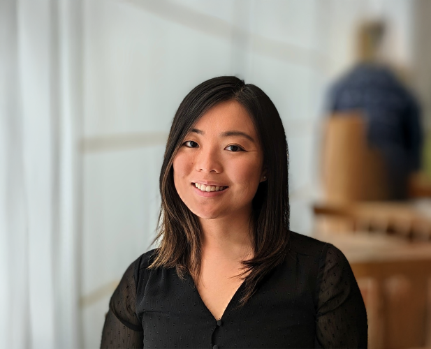 A color photo of a woman smiling for a photo.