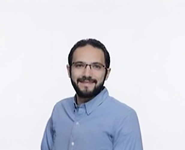 A color photo of a man smiling for a portrait.