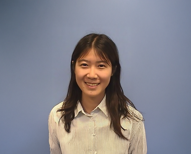 A color photo of a woman smiling for a photo.